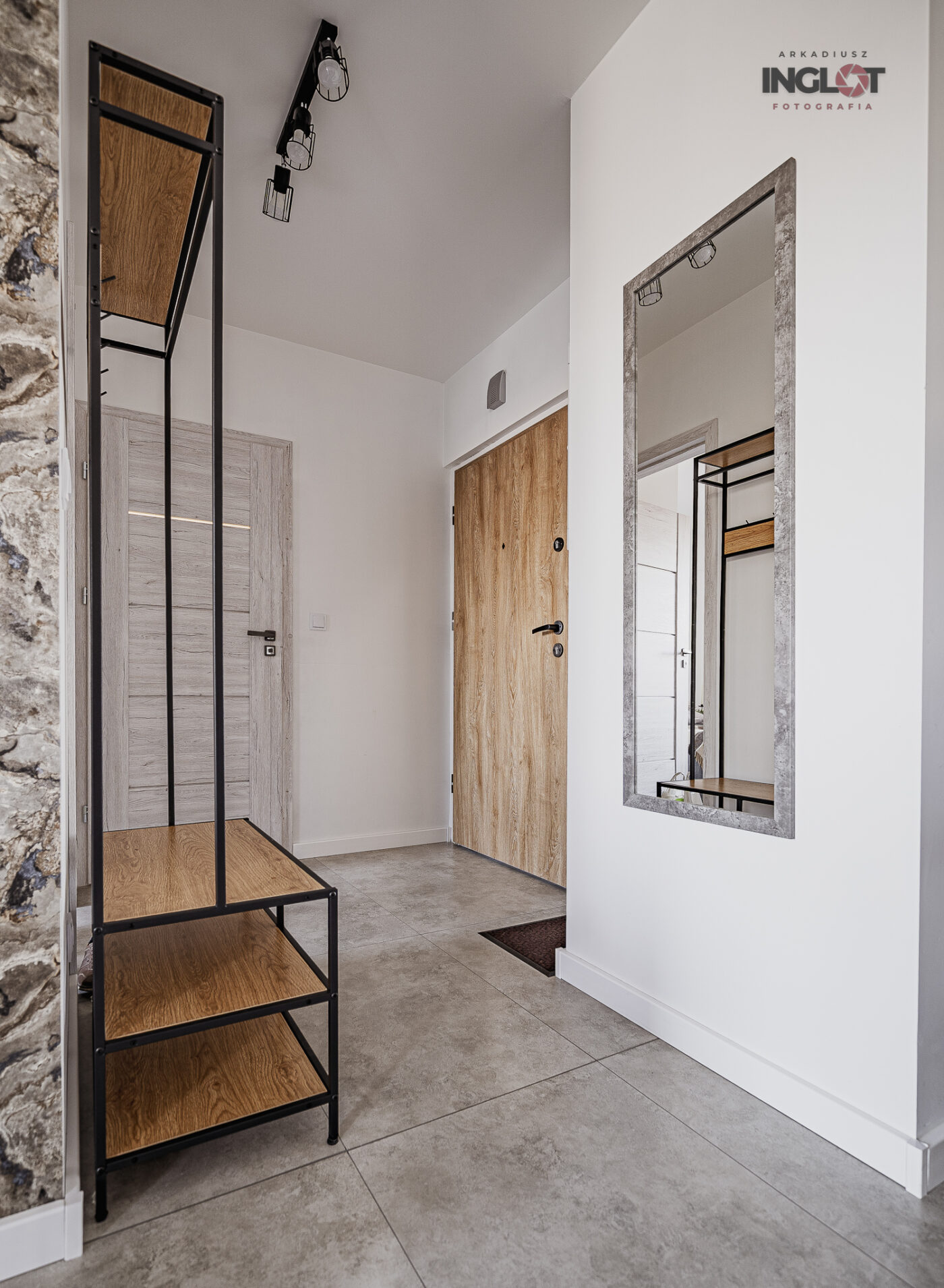 Nowoczesny przedpokój z wejściami do pokoju, salonu i łazienki, urządzony w jasnej, minimalistycznej stylistyce.