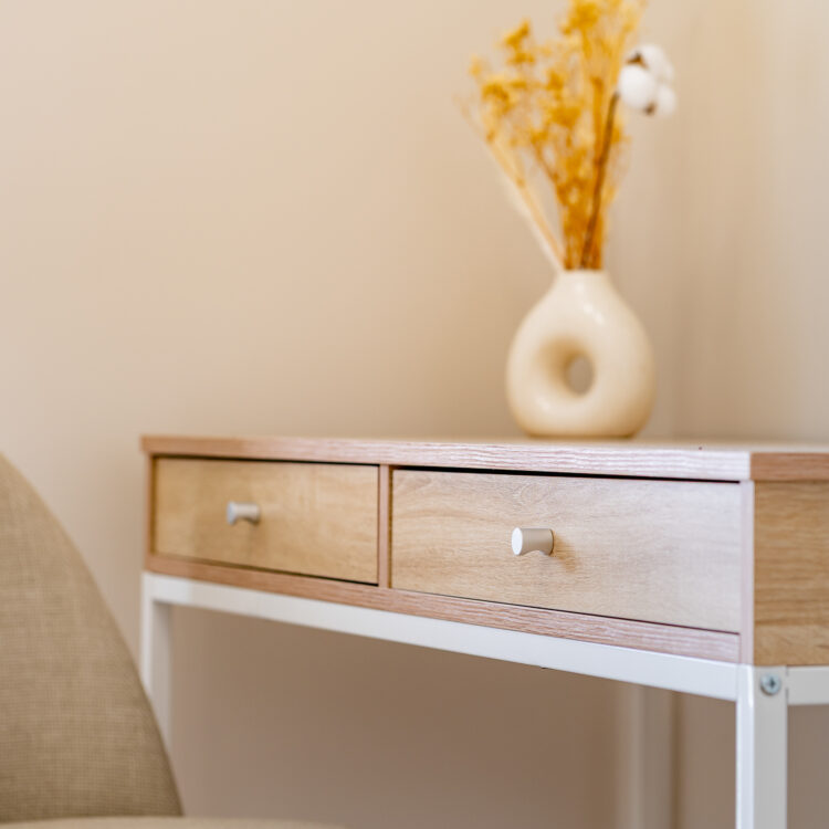 Minimalistyczne biurko z drewnianym blatem i jasnymi dodatkami w sypialni.