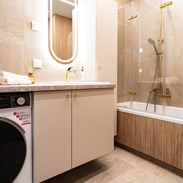 Szafka z umywalką w nowoczesnej łazience z jasnymi płytkami.