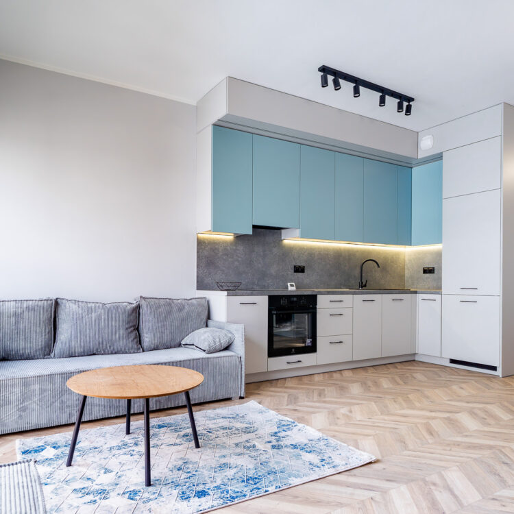 Aneks kuchenny z pastelowo-niebieskimi frontami i szarym blatem.