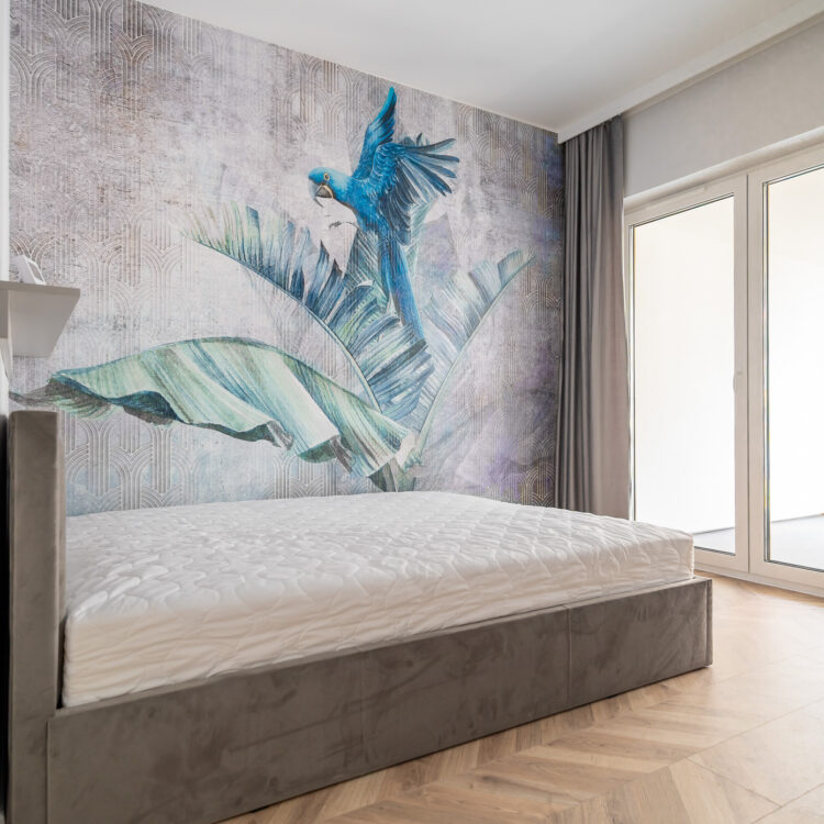 Przytulna sypialnia z wyjściem na balkon i dużą fototapetą z niebieskim ptakiem, nowoczesne i stylowe wnętrze.