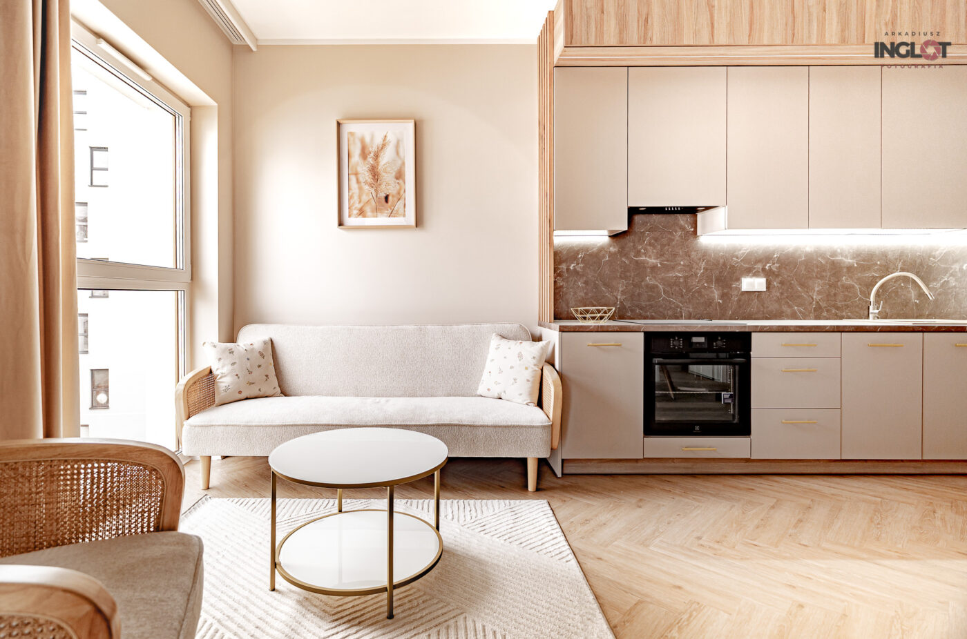 Jasna sofa i kuchnia w mieszkaniu w stylu boho.