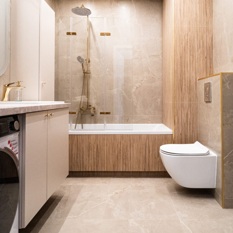 Łazienka wzdłuż z jasnymi płytkami i drewnianymi dodatkami.