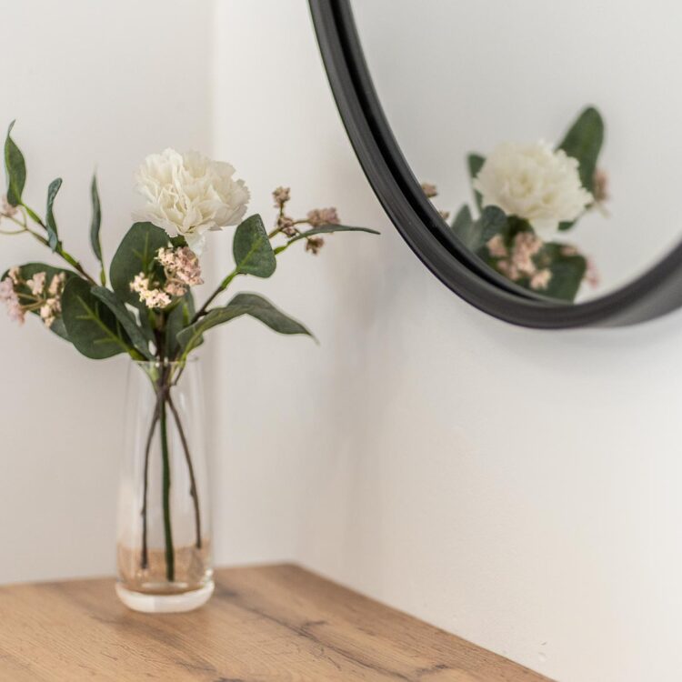 Półka z rośliną i lustrem – estetyczny detal wnętrza.