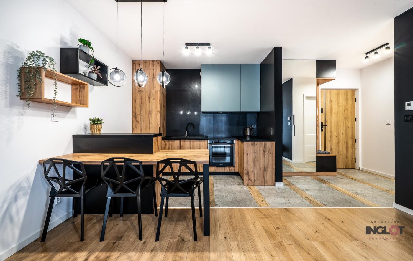 Jasna kuchnia z czarnym blatem – zdjęcie wnętrza.