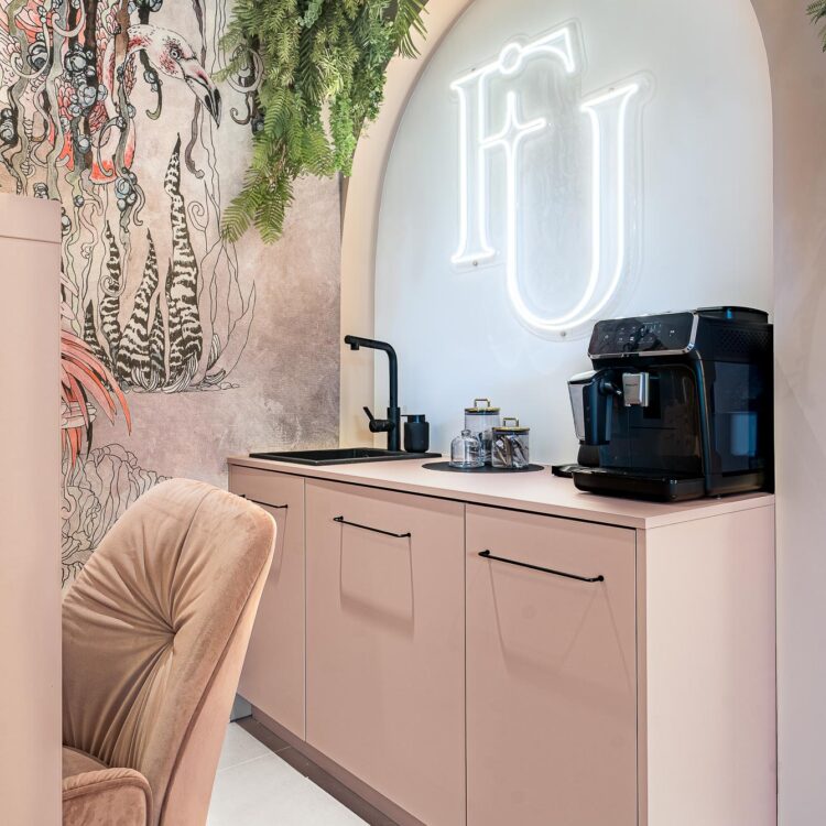 Recepcja salonu kosmetycznego w różowej aranżacji.